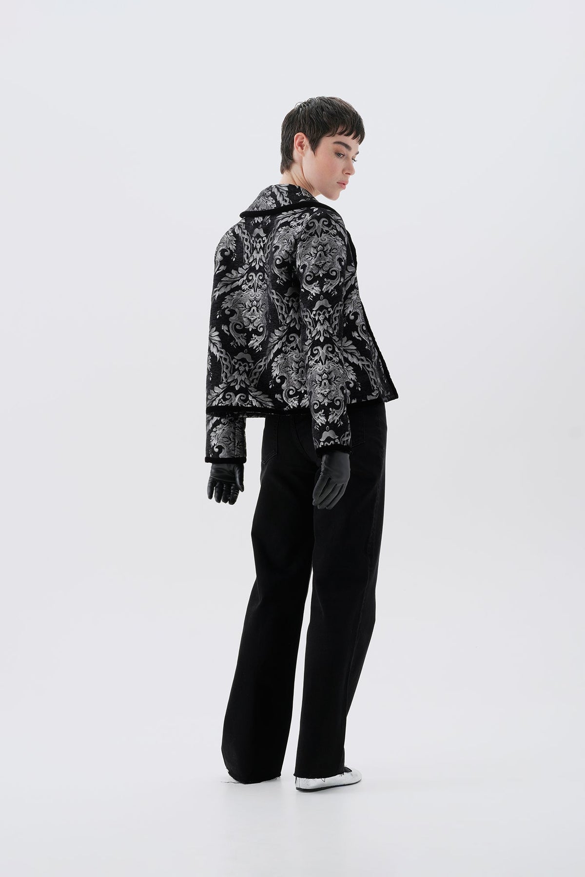 Black and silver patterned jacket, side view, paired with black pants