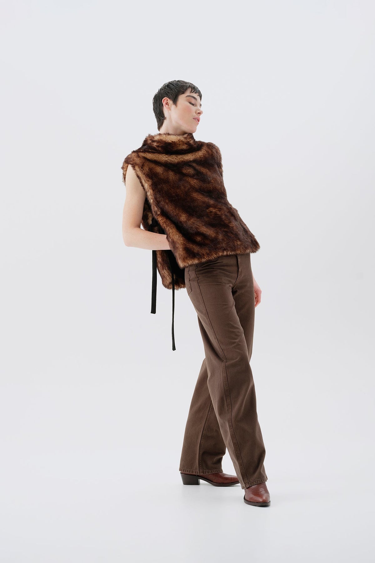Model wearing a brown faux fur vest and matching pants on a white background