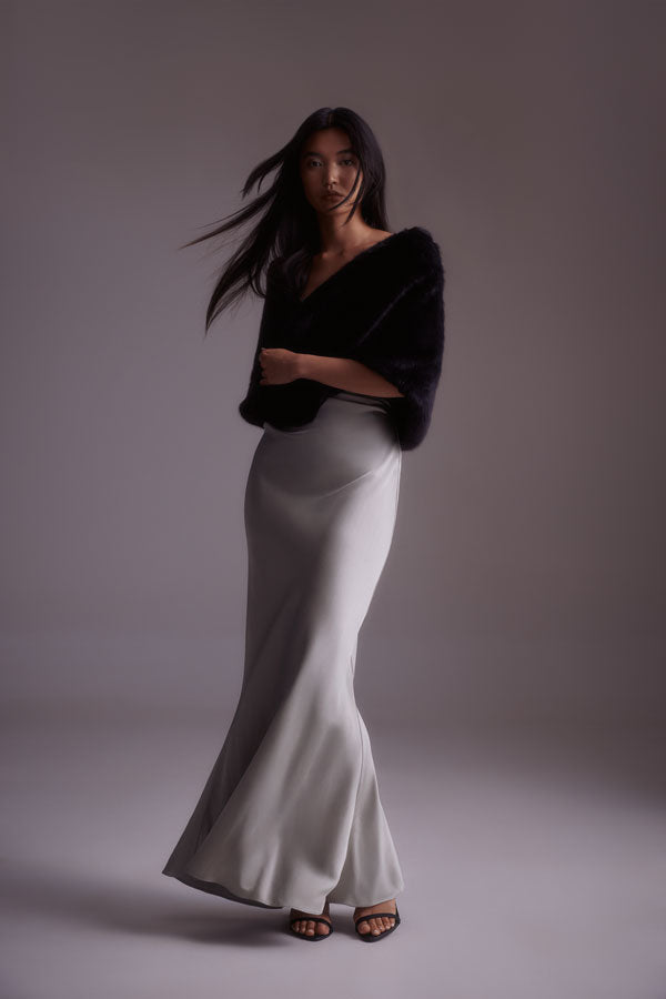 Woman wearing a black faux fur wrap and white dress