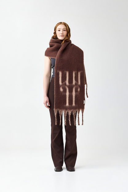Model wearing a brown scarf with a reversible beige color and the brand logo on a white background