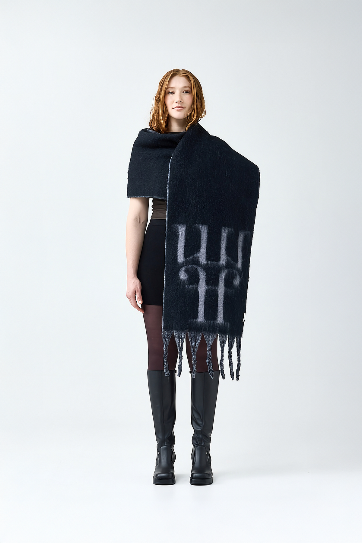 Model wearing a black scarf with a reversible grey color and the brand logo on a white background