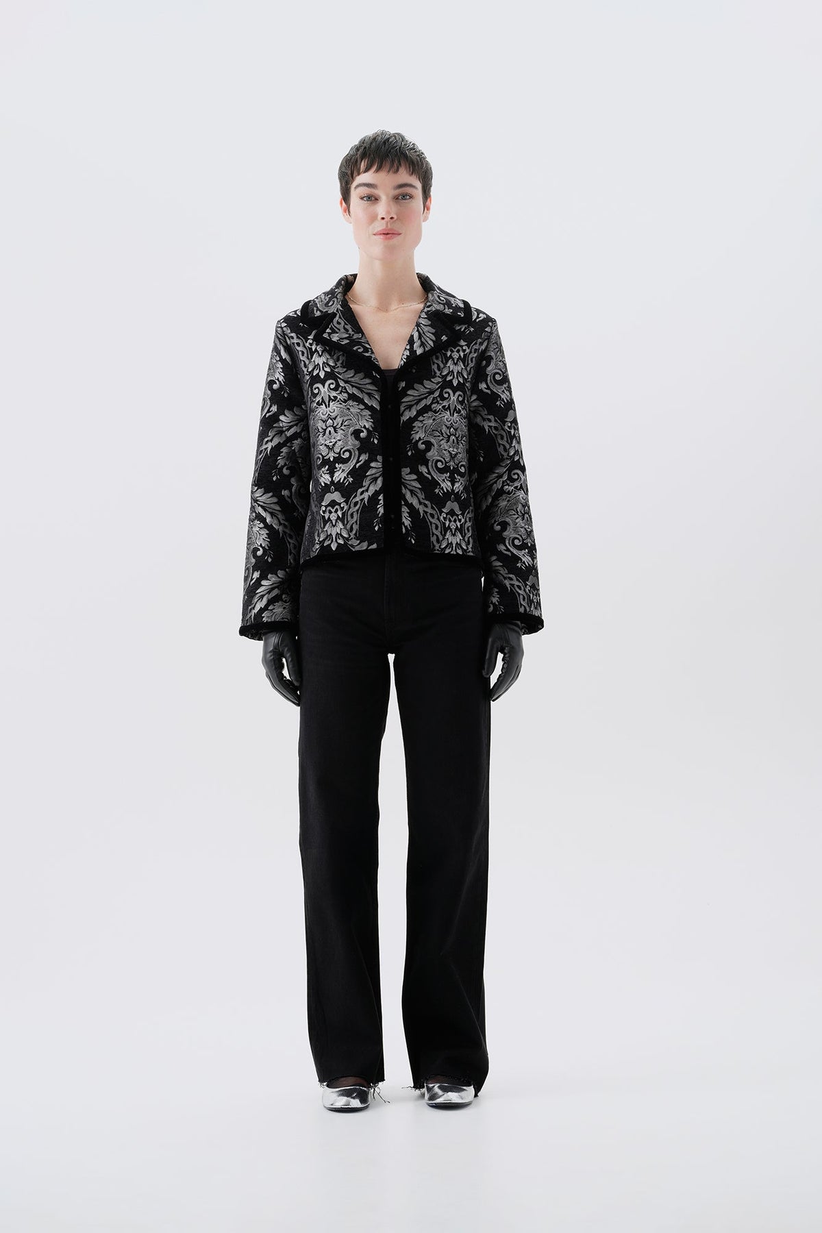 Black and silver patterned jacket, front view, paired with black pants