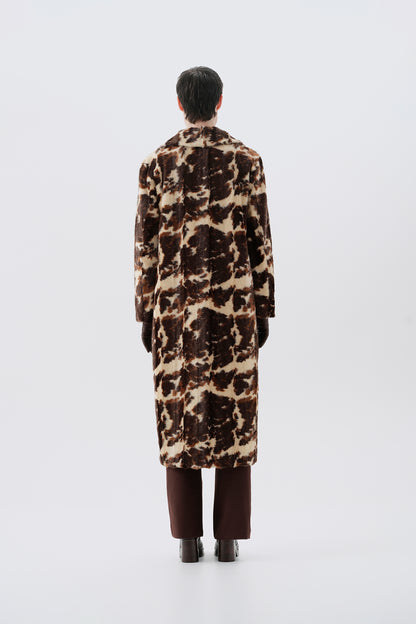 Model wearing a faux fur cow print long coat on a white background
