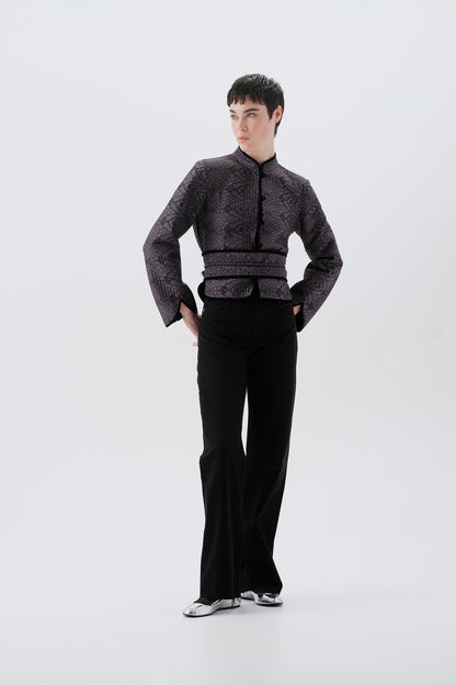 Model wearing a gray jacket with oriental patterns and a black reversible side