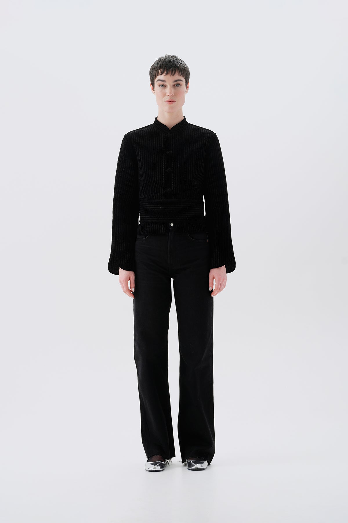 Model wearing a black jacket with gray reversible side with oriental patterns 