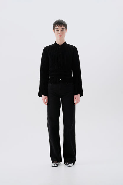 Model wearing a black jacket with gray reversible side with oriental patterns 