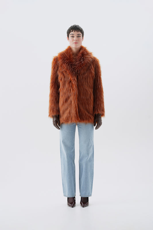 Model wearing a brown faux fur coat with a white background