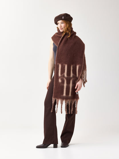 Model wearing a brown scarf with a reversible beige color and the brand logo on a white background