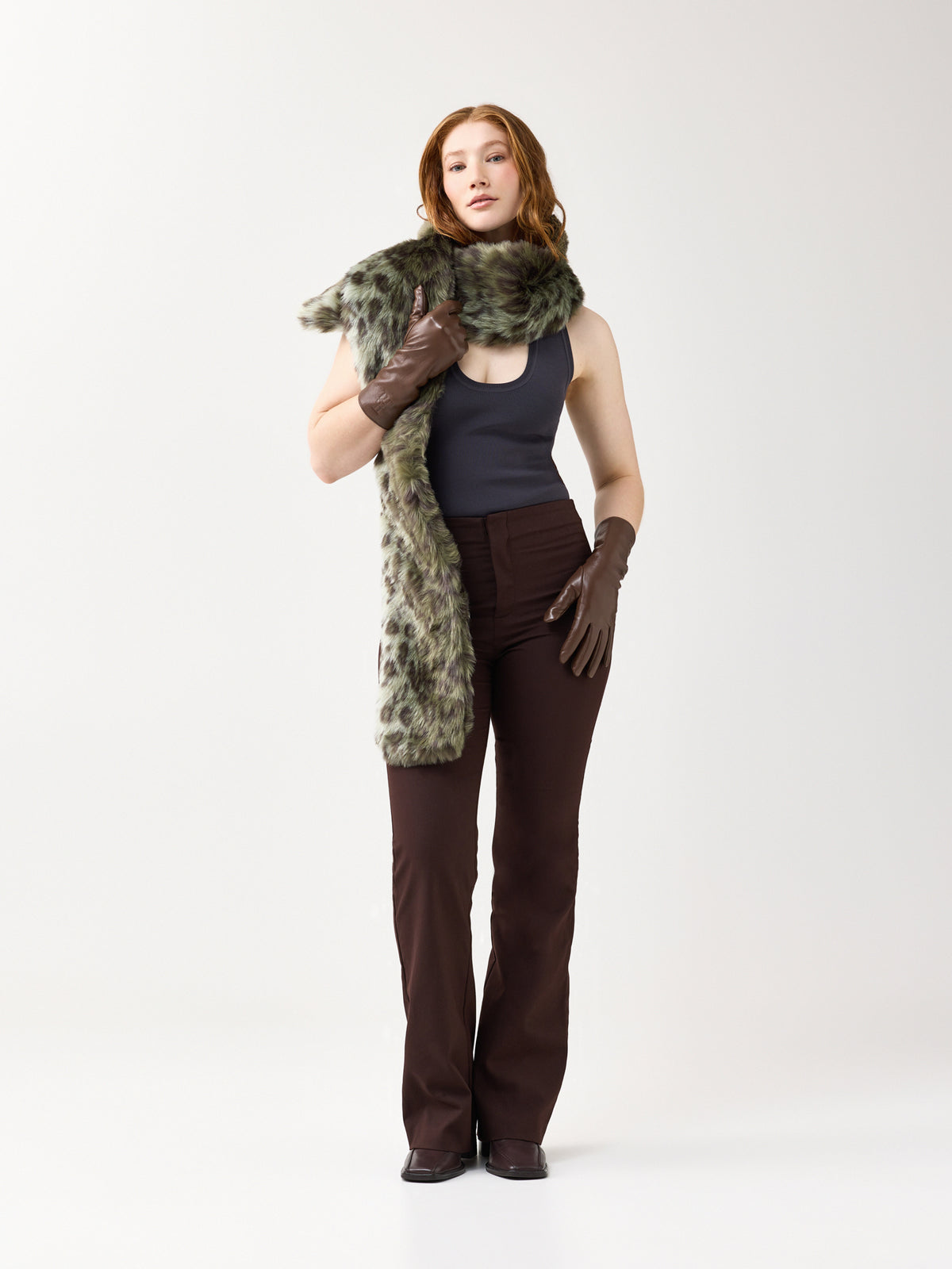 Woman wearing a green leopard faux fur scarf on a white background