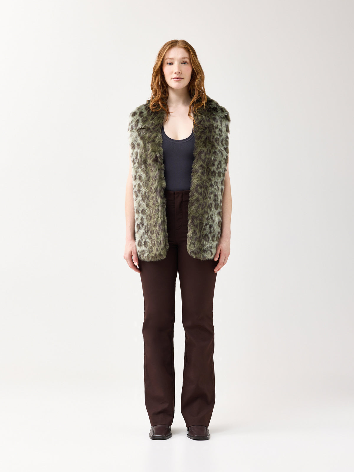 Woman wearing a green leopard faux fur scarf on a white background